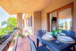a table with plates and wine glasses on a balcony at Villetta Monica in Costa Paradiso