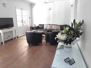 a living room with a couch and a table at Bunya Cottage at On Burgum Pond in Maleny