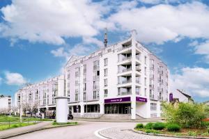 a white building on a street with a cloudy sky at Premier Inn Stuttgart Bad Cannstatt in Stuttgart