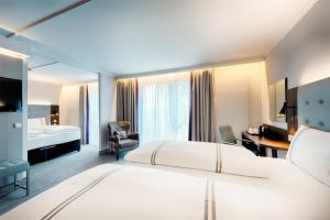 a hotel room with a large bed and a desk at Premier Inn Stuttgart Bad Cannstatt in Stuttgart +20 photos