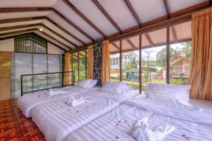 a large bed in a room with a large window at Villa Pinokio W BBQ & Backyard in Bandung