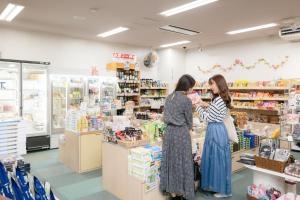two women are standing in a store aisle at Kur and Hotel Suruga in Shizuoka