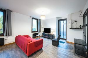 Una sala de estar con un sofá rojo y un televisor. en Appartement Aigueblanche, en La Lechere