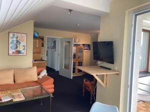 a living room with a couch and a table with a television at Helles Apartment mit Balkon in ruhiger Lage in Hameln