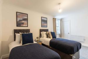 ein Schlafzimmer mit zwei Betten und einem Fenster in der Unterkunft Lovely 2BED Whitehaven Apartment with Sea Views in Whitehaven