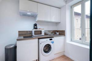 a kitchen with a washing machine and a microwave at Apartment Perron - Cozy 2 people - Oullins in Oullins