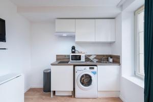 a kitchen with a washing machine and a microwave at Apartment Perron - Cozy 2 people - Oullins in Oullins