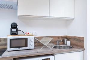 a kitchen counter with a microwave and a sink at Apartment Perron - Cozy 2 people - Oullins in Oullins