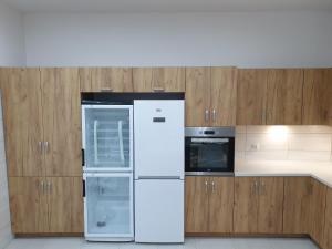 a white refrigerator in a kitchen with wooden cabinets at Willa Wierzbiczany in Gniewkowo