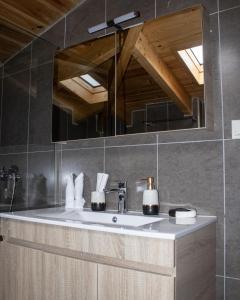 une salle de bain avec un lavabo et un miroir dans l'établissement Snow Chalets Parnassos, à Kalívia 53 autres photos