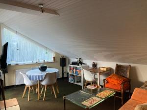 a living room with a table and some chairs at Helles Apartment mit Balkon in ruhiger Lage in Hameln