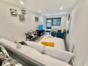 Una sala de estar con un sofá blanco y una mesa. en Seaside Escape - Central Studio Near Beach and Town, en Bournemouth