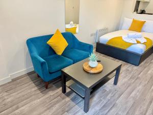 Habitación con cama, silla azul y mesa. en Seaside Escape - Central Studio Near Beach and Town, en Bournemouth 7 fotos más