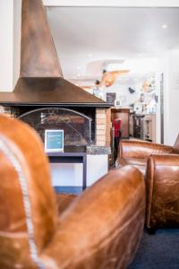 a living room with leather chairs and a fireplace at Villages Clubs du Soleil - VARS in Vars +17 photos