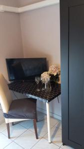 un tavolo nero con due bicchieri e fiori sopra di Hotel Blu a Rieti