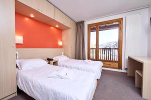 a hotel room with two beds and a window at Villages Clubs du Soleil - VARS in Vars