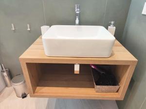 a white sink on a wooden stand in a bathroom at Casa Nanni in Genova
