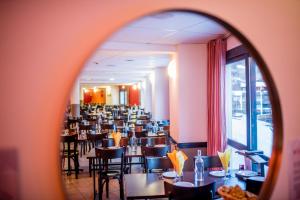 a dining room with tables and chairs and a mirror at Villages Clubs du Soleil - VARS in Vars