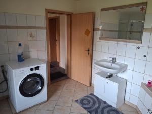 a bathroom with a washing machine and a sink at Gute Laune 3 in Zapel +6 photos