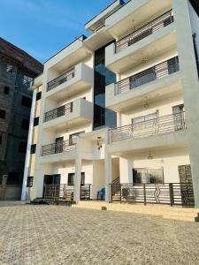 a large white building with balconies on it at Seaside Lodging in Limbe