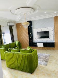 a living room with a green couch and a television at Seaside Lodging in Limbe