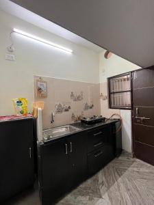 Una cocina con gabinetes negros y un fregadero. en Happy living 2, en Vijayawada