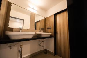 a bathroom with two white sinks and a mirror at La Roche Poshtel in Anjuna +42 photos