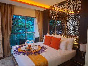 a bedroom with a bed with a flower arrangement on it at BAB ALHARA HOTEL in Patong Beach +290 photos