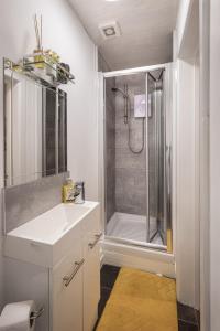 une salle de bain blanche avec une douche et un lavabo dans l'établissement 1 Double Bedroom Great Location - Holmfield Road, à Blackpool
