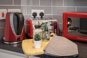 un grille-pain rouge posé sur un comptoir de cuisine avec un cactus dans l'établissement 1 Double Bedroom Great Location - Holmfield Road, à Blackpool