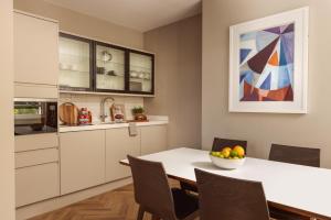 a kitchen with a white table and chairs at Native Hyde Park in London