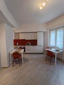 a kitchen with white cabinets and a table and chairs at Casa Nanni in Genova