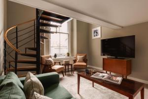 a living room with a spiral staircase and a living room at Native Hyde Park in London