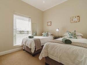 a bedroom with two beds and a window at Manor One Kingswood Golf Estate in George +15 photos