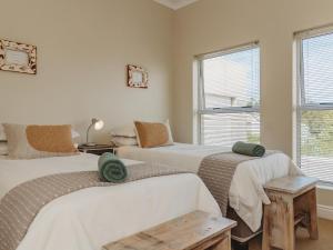 a bedroom with two beds and a window at Manor One Kingswood Golf Estate in George