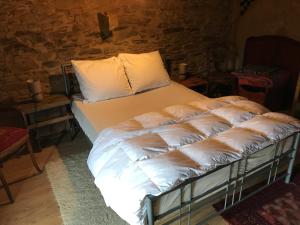 a bed with white sheets and pillows in a room at La Boutique Naturelle in Vresse-sur-Semois