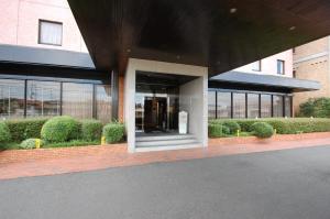 出雲市にある出雲ロイヤルホテルの茂みの前の建物入口