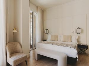 a bedroom with a large white bed and a chair at Molina Lario in Málaga +55 photos