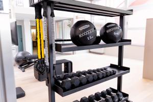 a gym with dumbbells and weights at Hotiday Diano Marina in Diano Marina