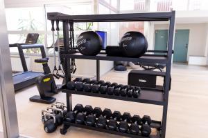 a rack with dumbbells and weights in a gym at Hotiday Diano Marina in Diano Marina