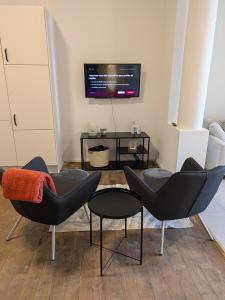 a living room with two chairs and a table at La Terrasse des Guillemins by WelcHome in Liège