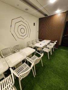 a room with white tables and chairs and a painting on the wall at LiLi HOTEL vip in Mansoura