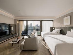 a hotel room with two beds and a tv at Shanghai Shang Ying CHAO Hotel in Shanghai