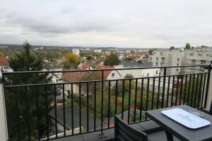 Un balcón con una mesa y vista a una ciudad. en Appartement Elégant & Raffiné, en Noisy-le-Grand