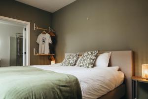a bedroom with a bed with pillows and a closet at La Terrasse des Guillemins by WelcHome in Liège