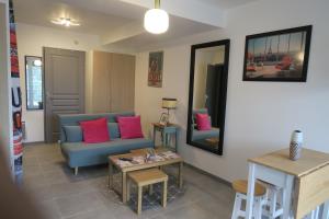sala de estar con sofá azul y almohadas rosas en Appartement Elégant & Raffiné, en Noisy-le-Grand