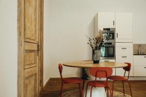 a kitchen with a table and four chairs at La Terrasse des Guillemins by WelcHome in Liège