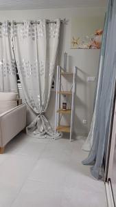 a living room with white curtains and a couch at Bungalow Le Petit Havre Pointois in Basse-Pointe +5 photos