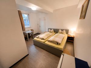 a bedroom with a bed and a desk and a window at Monteurunterkunft Zum Mohr in Birstein