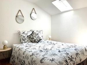 a bedroom with a bed and two mirrors on the wall at La Petite Lorraine in Bertrambois